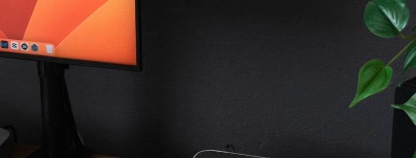 a desk with a laptop, keyboard, mouse and a monitor