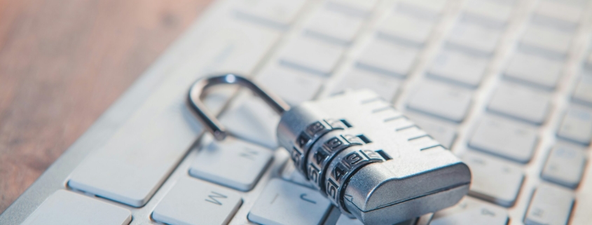 A combination lock rests on a computer keyboard.