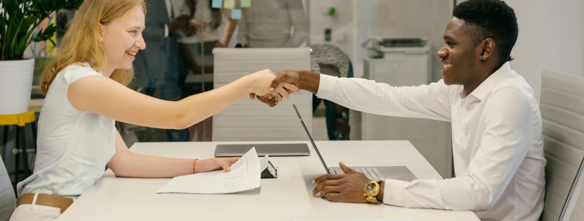Free Business professionals completing a successful deal with a handshake in a modern office setting. Stock Photo