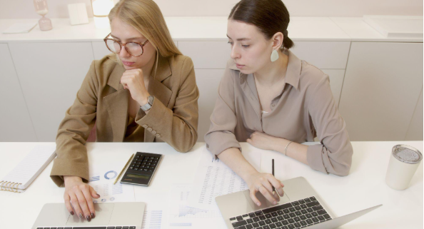 two women with laptops